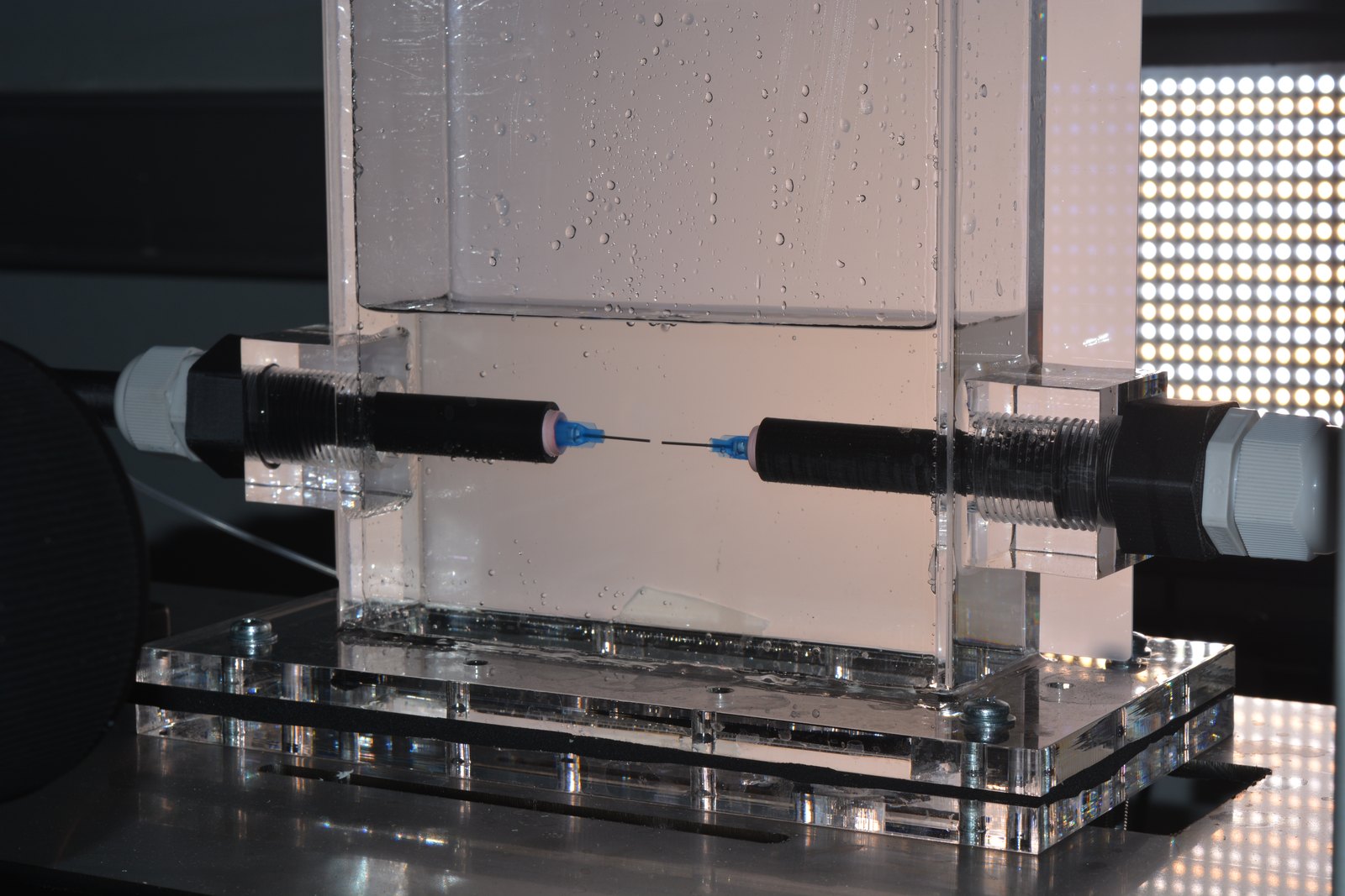Two facing capillaries inside a small-scale cell, backlit for high-speed imaging