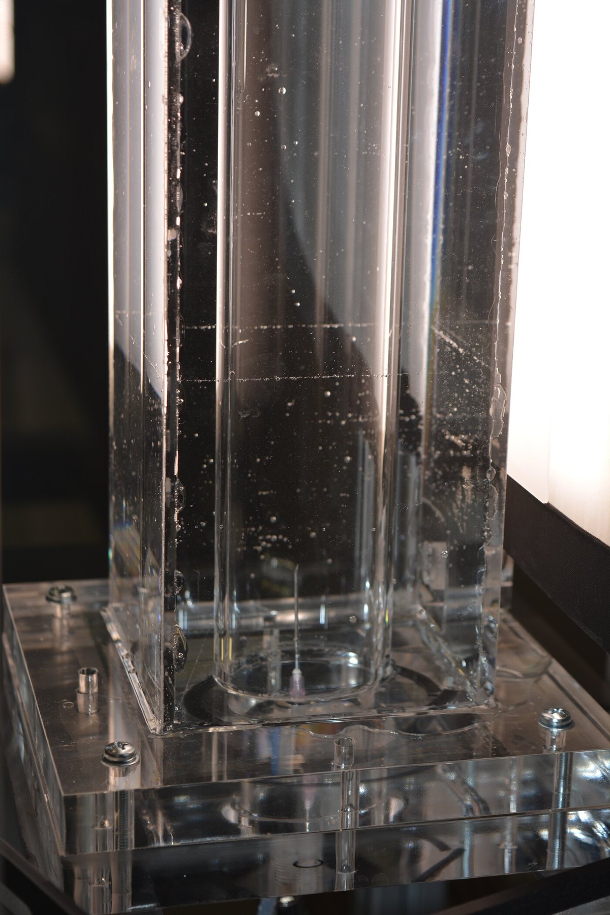 A small-scale acrylic column with a single needle injector at its base